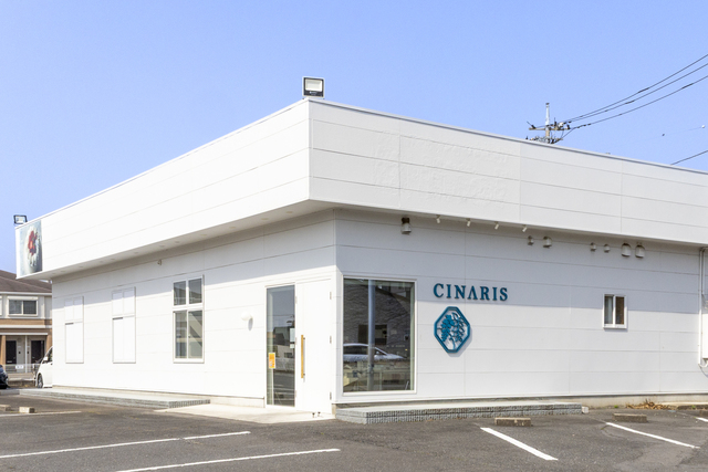 真っ白な建物に「CINARIS」のロゴと文字が目立つ外観